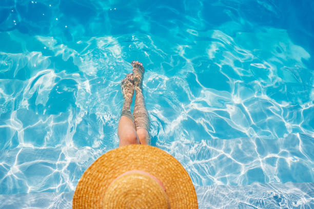 istock top view. a woman in a straw hat in the pool. 1428360559