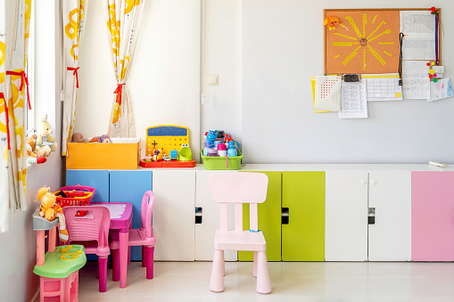 Kindergarten Classroom With Table, Colourful Chairs and Toys.
