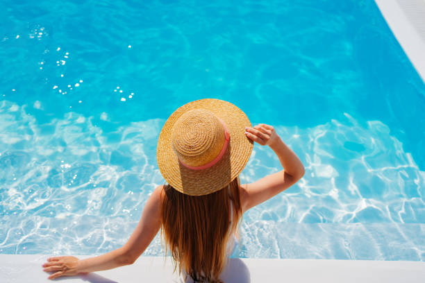 istock top view. a woman in a straw hat in the pool. 1428361369
