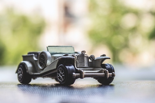 A closeup of an antique gray car toy on a table