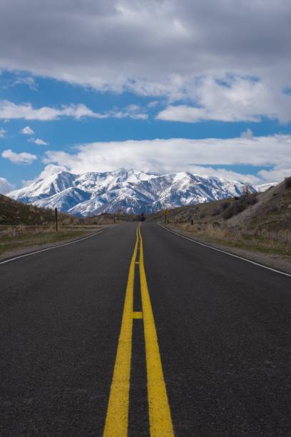 istock Highway road heading towards a snowy mountain 1428362606