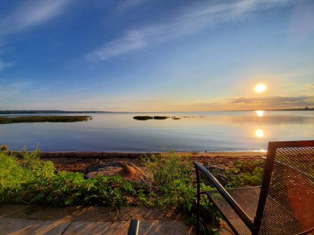 istock Empty chair facing a calm lake during sunrise 1428365243