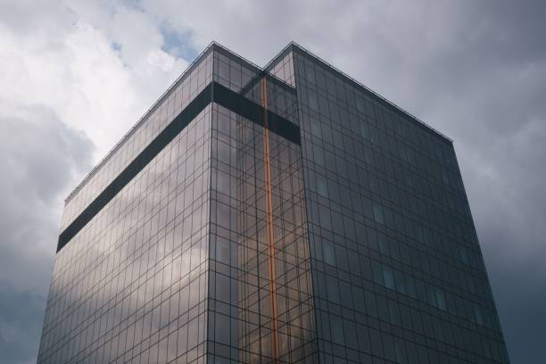 istock Low-angle shot of the modern building with transparent windows against a clouded sky 1428366489