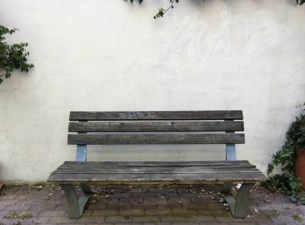 istock Wooden bench near a white wall 1428373587