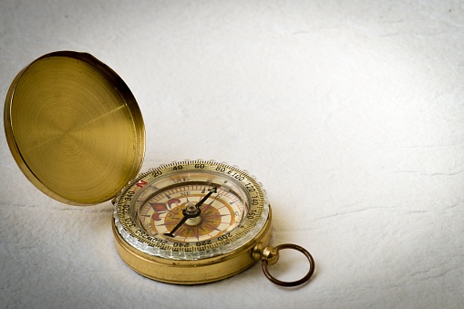 A vintage compass on a white handmade paper