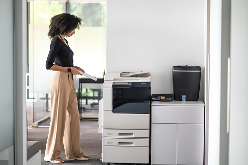 Office .Woman in balck shirt and beige pants in the office looking determined