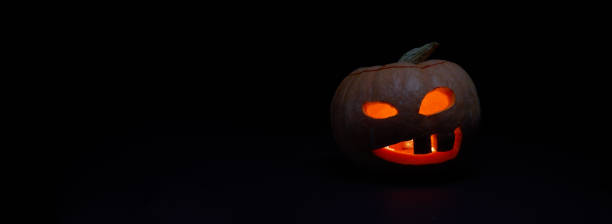 istock Halloween pumpkin with burning mouthst on dark background. 1428377951