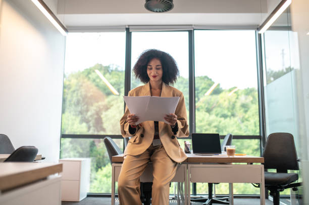 istock Manager in beige suit checking papers and looking involved 1428378500