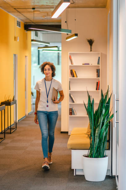 istock Office worker walking in the office corridor and looking contented 1428379592