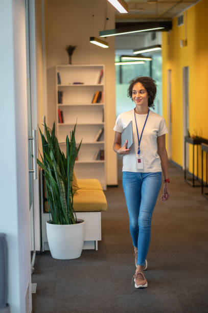 istock Office worker walking in the office corridor and looking contented 1428379633
