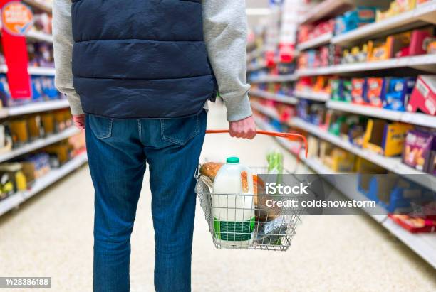 Man Holding Shopping Basket With Bread And Milk Groceries In Supermarket Stock Photo - Download Image Now