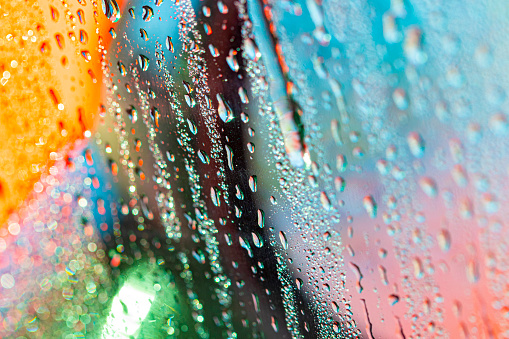 Close-up of water drops on a coloured surface