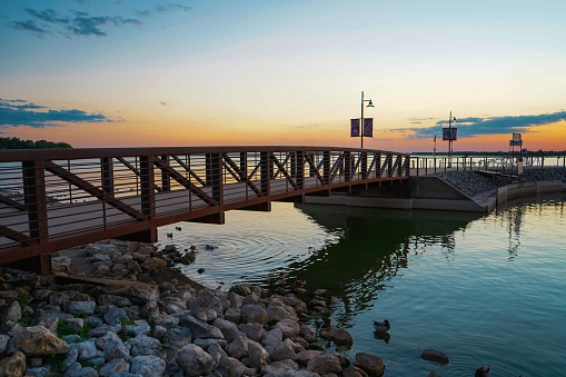 The rocky shore with a bridge against the sky at sunset. Dallas, Texas.
