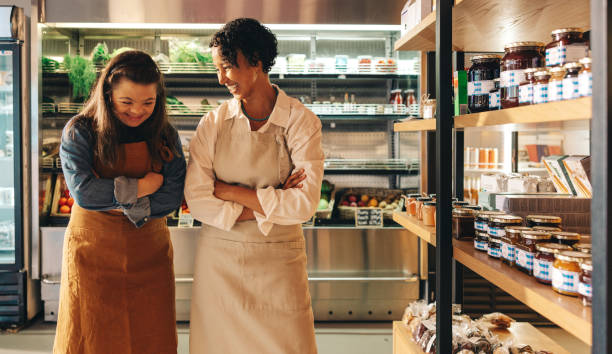 istock Two grocery store workers laughing happily in their shop 1428387860