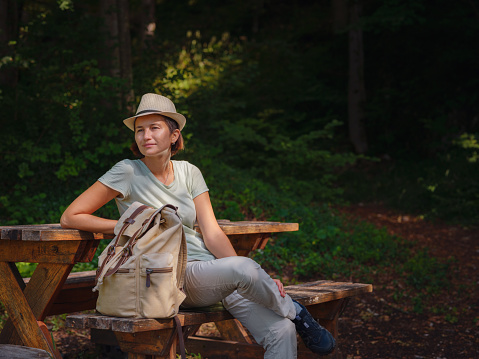 travel to summer Europe young asian woman. observation point above the village of Roggenburg, Switzerland. hike in summer forest, having a break