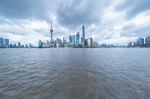 shanghai skyline in cloudy day, showing the Huangpu river with passing cargo ships, and financial district, empty marble floor and cloudy sky background