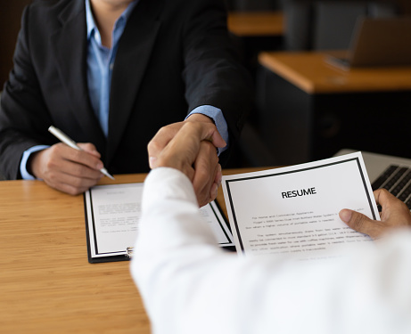 Good deal. Business, career and placement concept - employer in office shaking hand of employee after successful job interview.