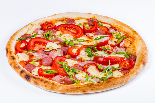 Pizza with cheese, tomatoes, peppers, green onions, sausages and bacon on a white background