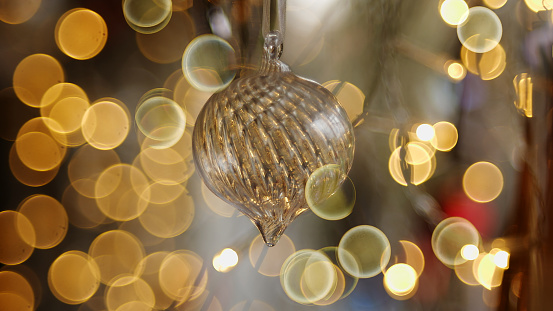 Stock photograph of a Christmas bauble surrounded by out of focus Christmas lighting.