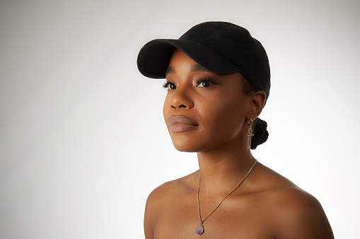 Lovely black woman in a baseball cap wearing a necklace