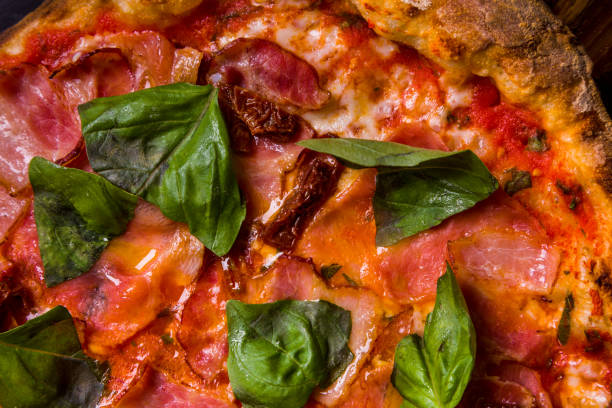 istock Pizza with prosciutto cheese, basil, bacon, pepper and sauce on a plate on the table 1428398715
