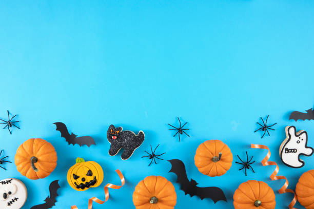 istock Halloween Decorations Pumpkins Candies Bats on Blue Background 1428400388