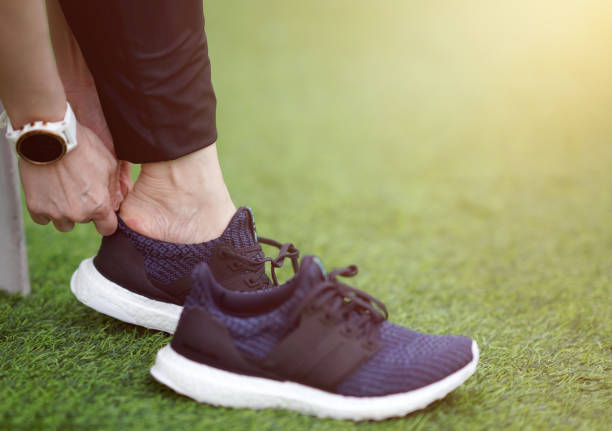 istock runner wearing running shoe on lawn with golden sun 1428400973