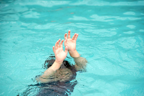 emergency kid drowing in swimming pool show up two hand call for help stock photo