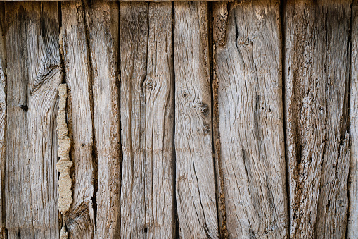 front view closeup of rustic weathered brown barn wood background with knots and nail holes
