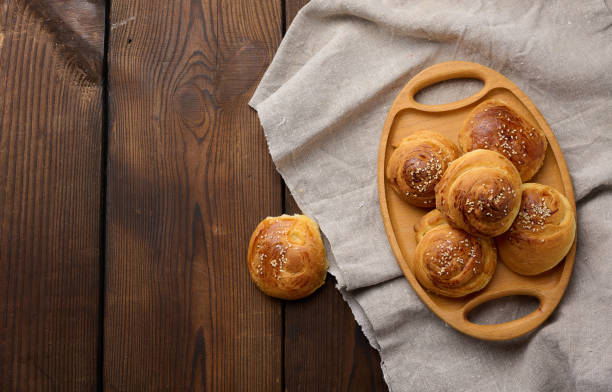 istock Baked round buns on a wooden table, top view 1428404174