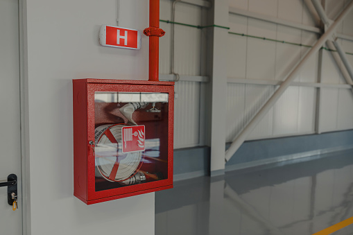 Pull station fire alarm system attached to a white wall used for training of security guards.