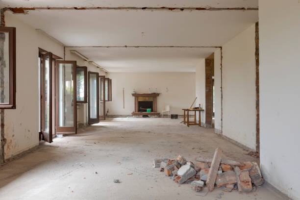 Large bright room with many windows of an old villa undergoing demolition and renovation. The walls have been knocked down and the floor is gone stock photo
