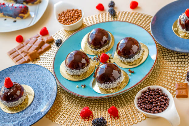 istock cupcake with chocolate cream. Chocolate round cake with raspberry set on a blue plate and chocolate decor on a beige table.Berry dessert.Delicate airy cake souffle.Appetizing pastries.Choux pastry. 1428406603