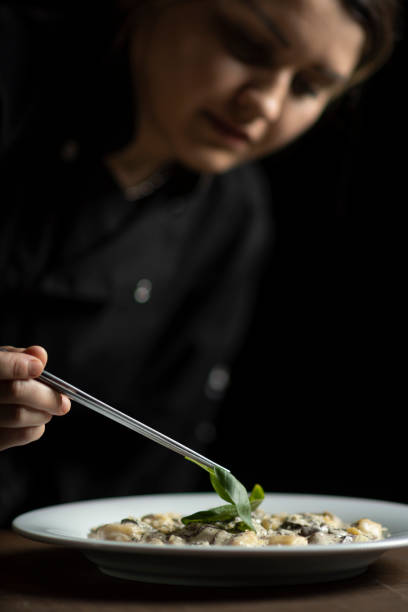 Closeup of female chef in restaurant decorates the meal stock photo