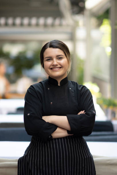 Happy female chef working at a restaurant and looking at the camera smiling stock photo