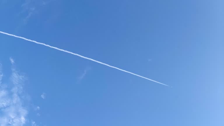 Jet contrail up in the air crossing the blue sky. Cloudscape, Japan.