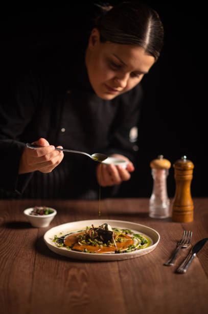 istock Female chef pouring sauce on meal 1428410542