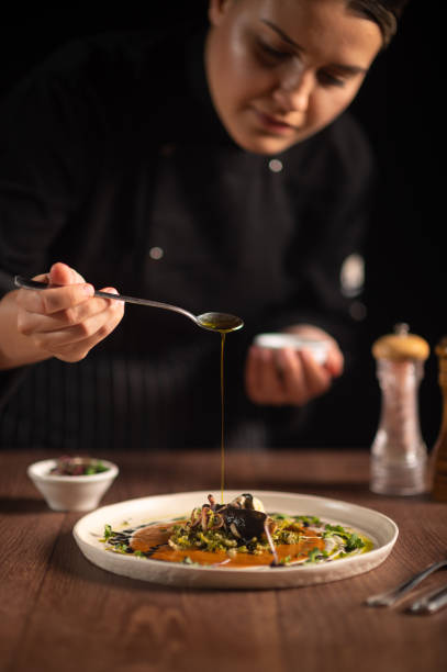 istock Female chef pouring sauce on meal 1428410559