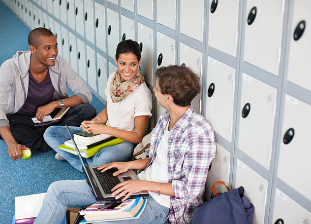 University students studying against lockers in corridor  apple with bite out of it stock pictures, royalty-free photos & images