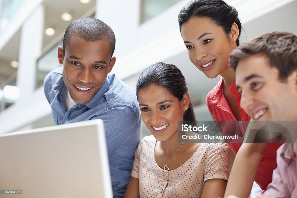 Universidad los estudiantes usando computadora portátil - Foto de stock de Cuatro personas libre de derechos