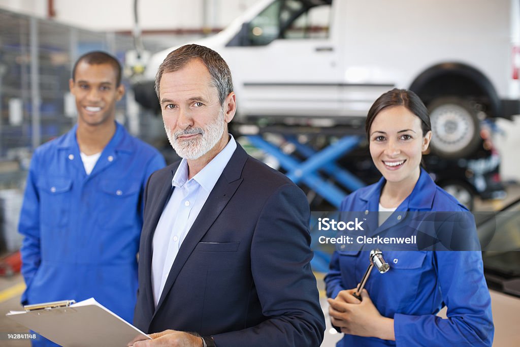 Porträt von lächelnd Mechanik und Geschäftsmann in auto-Reparatur sho - Lizenzfrei Autowerkstatt Stock-Foto