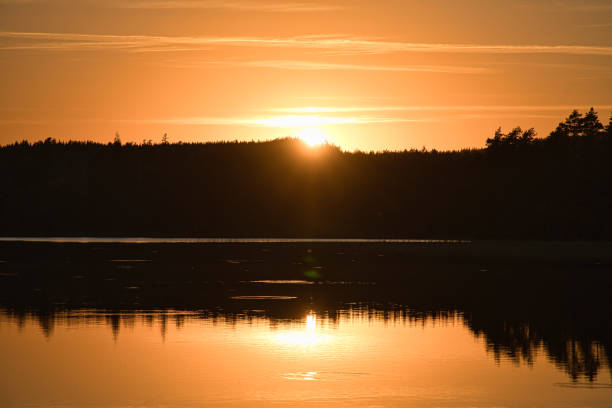 Sunset with reflection on a Swedish lake in Smalland. Romantic evening mood