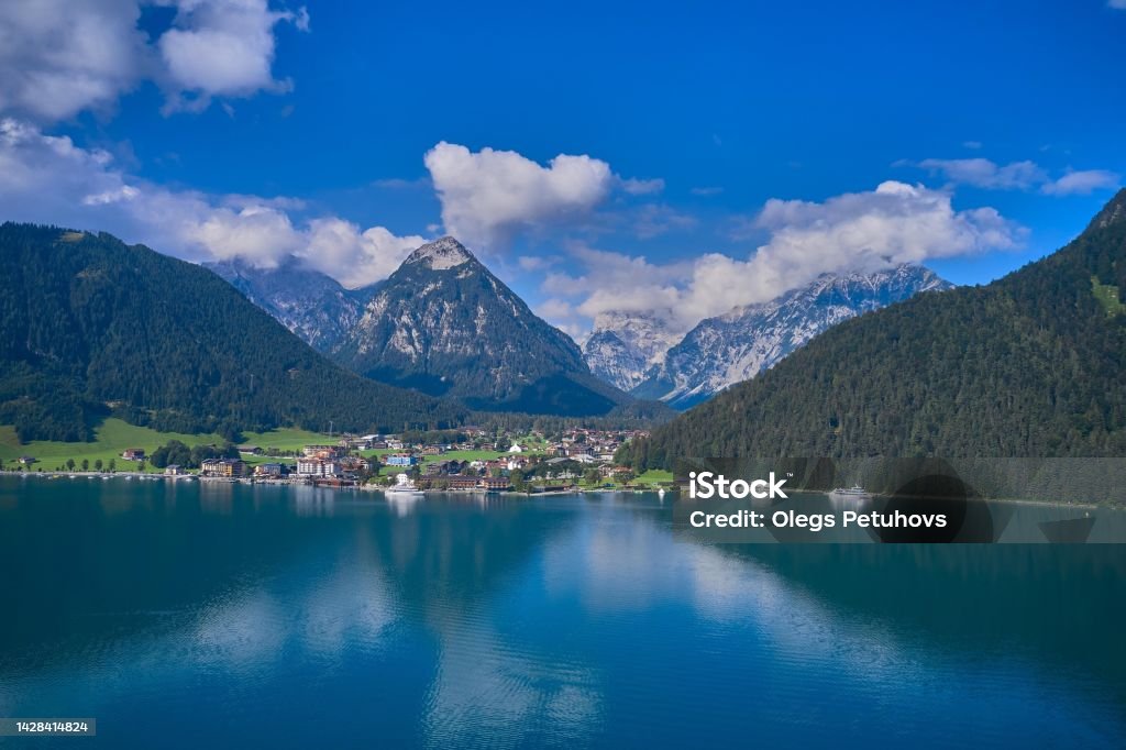 the beautiful view of an alpine lake and mountains, there is a view of the mountains, water and boats Mountain Stock Photo