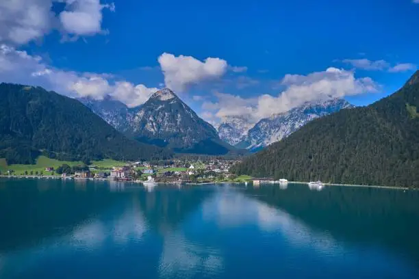 the beautiful view of an alpine lake and mountains, there is a view of the mountains, water and boats