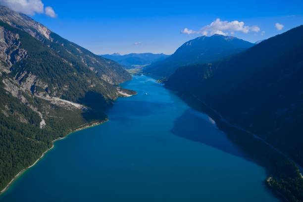 istock a view from a helicopter shows the mountain side, blue waters and mountains with sky in background 1428414902