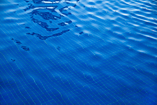 Bottom of the swimming pool with blue water