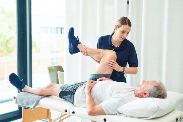 Physiotherapy doctor, senior patient and leg surgery, physical therapy and orthopedic healing. Physiotherapist, chiropractor and nurse help elderly injury, osteoporosis and arthritis rehabilitation stock photo