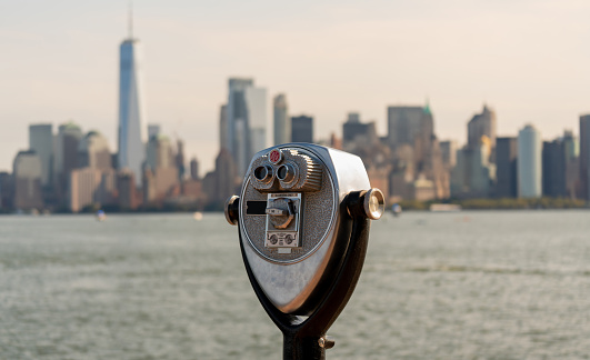 Tourist binoculars on Liberty Island overlooking downtown Manhattan, New York, USA.