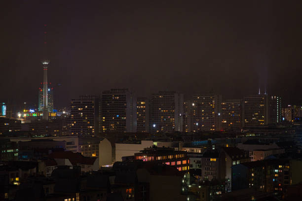 Night view of Berlin with TV tower in the city center. In December it gets dark early and creates wonderful views of the city. The center of the image is dominated by tall apartment buildings. The lights of the city draw a colorful picture. Some houses are brightly lit.