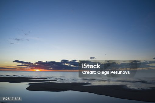 istock Landscape sunset scene on the west coast of Ireland with last light shining through storm clouds reflected in sea during stormy weather in summer in county Kerry. 1428421343